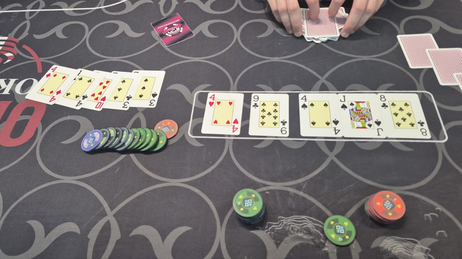 Mão de Omaha aberta ao lado do board, com pilhas de fichas na mesa